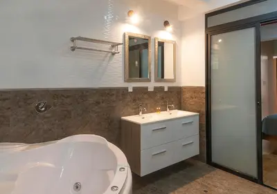 a bathroom with a tub and a sink and a mirror at Hotel Precursores in Lima