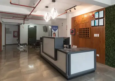 a man standing at a reception desk in a lobby at Hotel Precursores in Lima