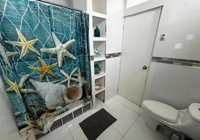 a bathroom with a shower curtain with a starfish at Playa Arica Backpackers in Arica