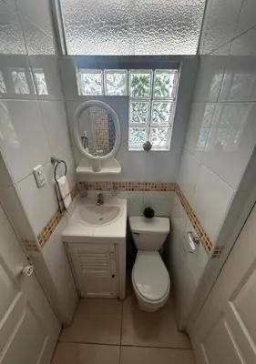 a small bathroom with a toilet and a sink at Playa Arica Backpackers in Arica