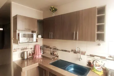a kitchen with wooden cabinets and a blue sink at Depawanka 2 in Huancayo