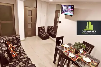 a living room with a table and chairs and a television at Depawanka 2 in Huancayo