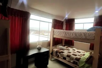 a bedroom with a bunk bed and a desk and a window at Depawanka 2 in Huancayo