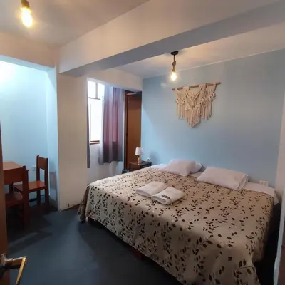 a bedroom with a bed with two towels on it at Hospedaje Hamuy's Lodge in Ica