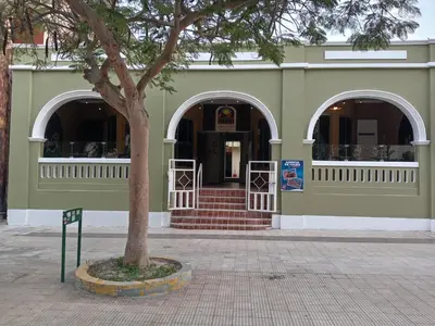 a green building with a tree in front of it at El Boulevard de Huacachina in Ica