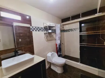 a bathroom with a white toilet and a sink at Hotel del Valle in Huancayo