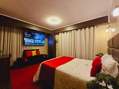 a bedroom with a bed and a tv on the wall at Hotel del Valle in Huancayo
