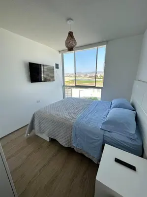 a bedroom with a bed and a large window at Apartamento de estreno San Bartolo vista Piscina Playa in San Bartolo
