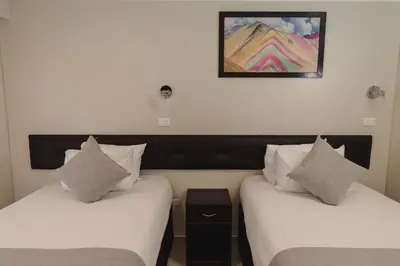 two beds in a room with a picture on the wall at Classic Hotel Cusco in Cusco