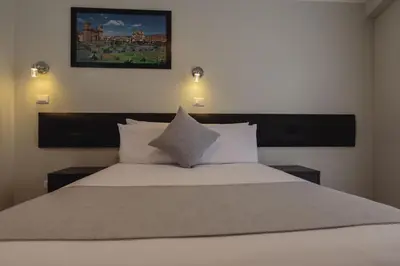 a bedroom with a large white bed with two pillows at Classic Hotel Cusco in Cusco