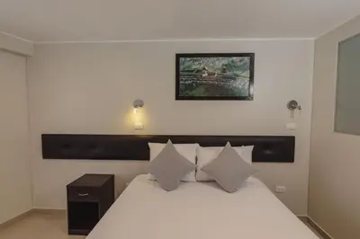 a bedroom with a white bed and a picture on the wall at Classic Hotel Cusco in Cusco