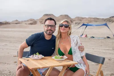 a man and woman sitting at a table on the beach at Acari Adventure & ski Resort in Acarí