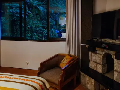 a bedroom with a couch and a tv and a fireplace at NaturaLodge Machu Picchu in Machu Picchu