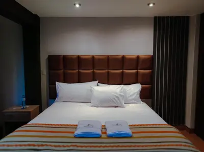 a bedroom with a large bed with two towels on it at NaturaLodge Machu Picchu in Machu Picchu