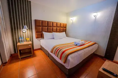 a bedroom with a bed with a stuffed animal on it at NaturaLodge Machu Picchu in Machu Picchu