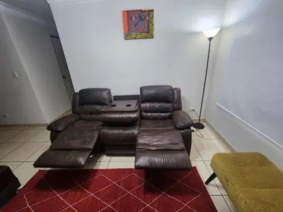 a living room with a leather couch and a table at rodrich business apartment in Lima