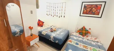 a bedroom with two twin beds and a mirror at Encanta Perú Apartment in Cusco