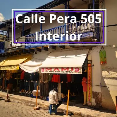 a woman walking past a store with a sign that readsalle pera inferior at Encanta Perú Apartment in Cusco