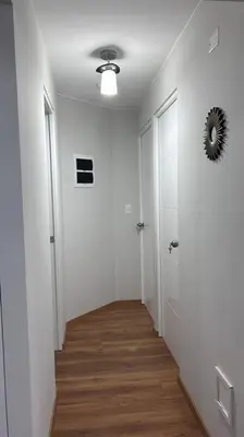 a hallway with white walls and a mirror on the wall at Departamento de Estreno - cerca a la Playa in Lima