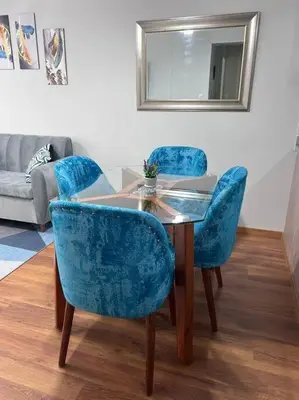 a table with two blue chairs and a mirror at Departamento de Estreno - cerca a la Playa in Lima