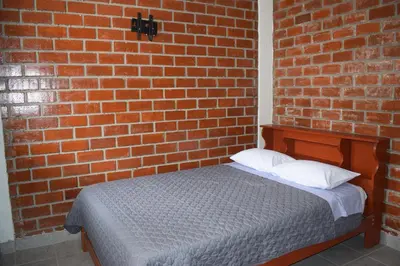 a brick wall with a bed in a room at El Valle - Lunahuaná in Lunahuaná