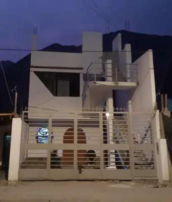 a white house with a gate in front of it at El Valle - Lunahuaná in Lunahuaná
