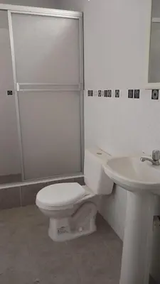 a white bathroom with a toilet and a sink at El Valle - Lunahuaná in Lunahuaná