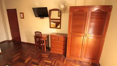 a room with a wooden cabinet and a desk with a mirror at Pretty House Hotel in Lima