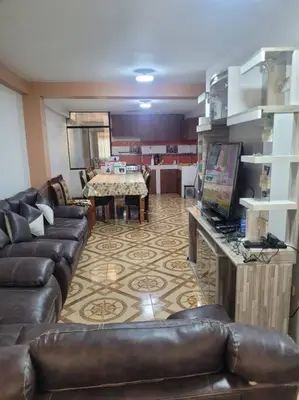 a living room with a leather couch and a television at Apartamento en Huancayo in Huancayo