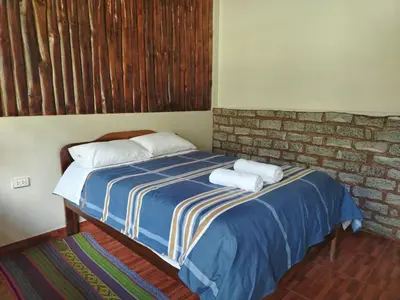 a bedroom with a bed with two towels on it at Lucmabamba Lodge in Santa Teresa