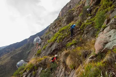 a group of people climbing up the side of a mountain at Skylodge Adventure Suites in Urubamba
