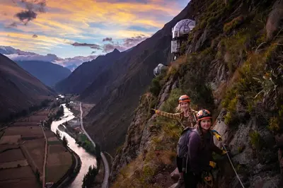two people standing on a mountain with a river at Skylodge Adventure Suites in Urubamba