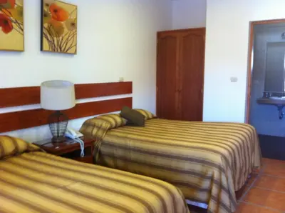 a hotel room with two beds and a lamp at Oro Viejo in Nazca