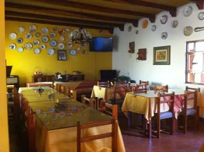 a restaurant with tables and chairs and plates on the wall at Oro Viejo in Nazca