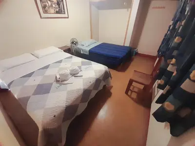 a bedroom with a bed and a table in it at Brabant Hostal in Nazca