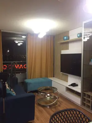 a living room with a blue couch and a tv at Bonito departamento VIP estreno en Condominio in Lima