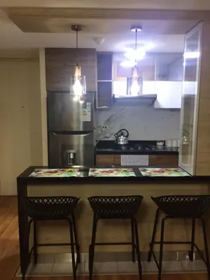 a kitchen with a counter with three chairs and a counter top at Bonito departamento VIP estreno en Condominio in Lima