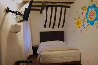 a bedroom with a bed and a painting on the wall at Cusco Lodge Hotel Boutique in Cusco