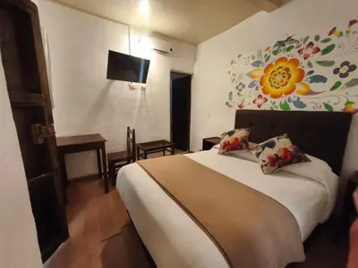 a bedroom with a bed with a flower painted on the wall at Cusco Lodge Hotel Boutique in Cusco
