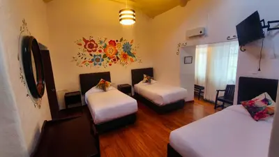 a room with two beds and a tv in it at Cusco Lodge Hotel Boutique in Cusco