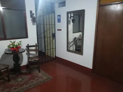 a hallway with a door and a chair and a table at Hospedaje Miraflores 17 in Lima