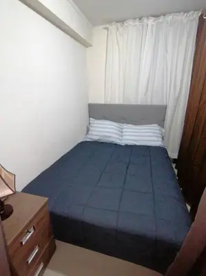 a small bedroom with a blue bed with a window at Mini departamento lujo in Lima