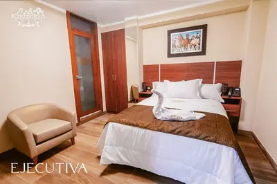 a hotel room with a bed and a chair at Hotel Kapadokya in Huánuco