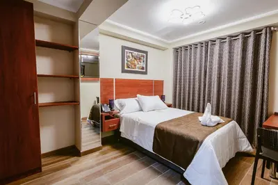 a hotel room with a bed and a desk at Hotel Kapadokya in Huánuco