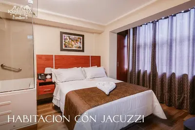 a bedroom with a bed and a large window at Hotel Kapadokya in Huánuco