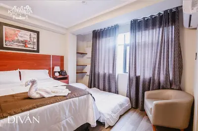 a bedroom with a swan on the bed and a chair at Hotel Kapadokya in Huánuco