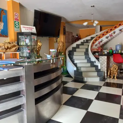 a lobby with a staircase in a restaurant at Hostal Luren in Nazca