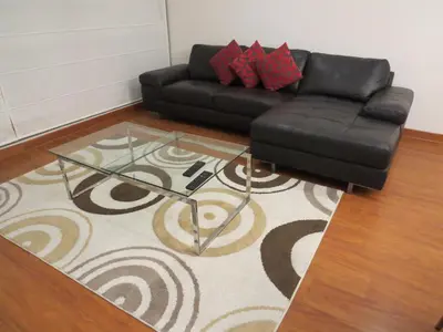 a living room with a black leather couch and a glass table at Spacious Apartment in Miraflores in Lima