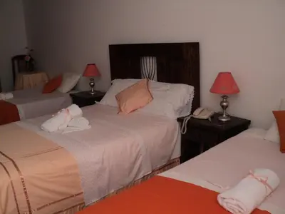 a hotel room with two beds and a phone at Hotel Conquistadores Inn in Ica