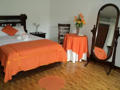 a bedroom with a bed and a table with a mirror at Hotel Conquistadores Inn in Ica